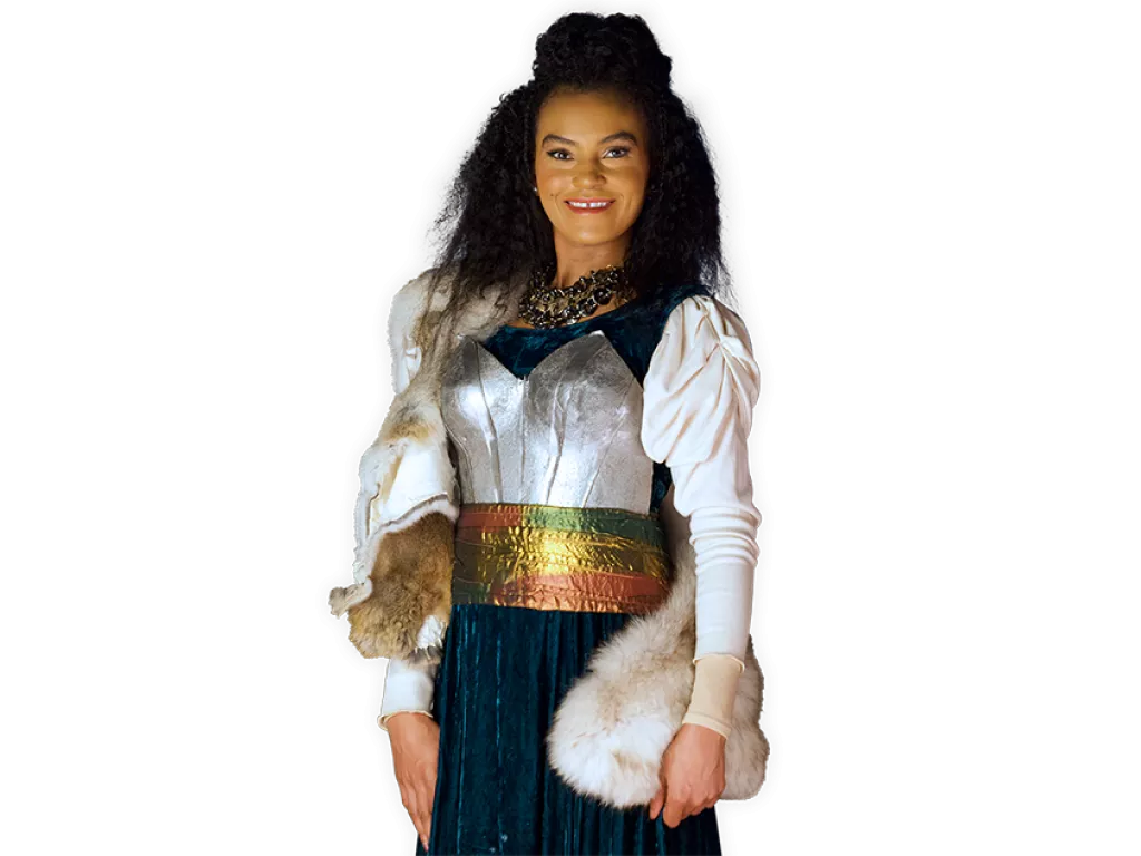 Viking Frida smiling and wearing a breastplate over her dress
