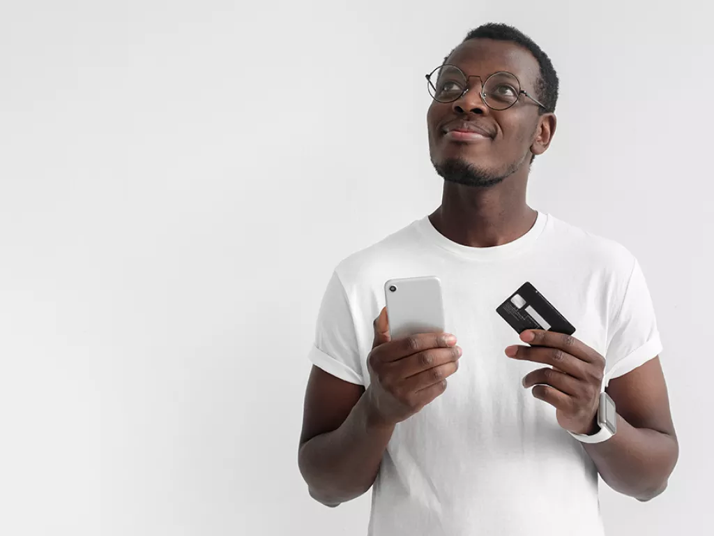 Man holding a credit card and cell phone