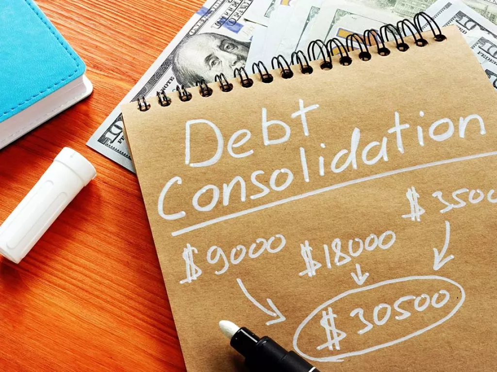 A notepad that says "debt consolidation" above several listed dollar amounts added together