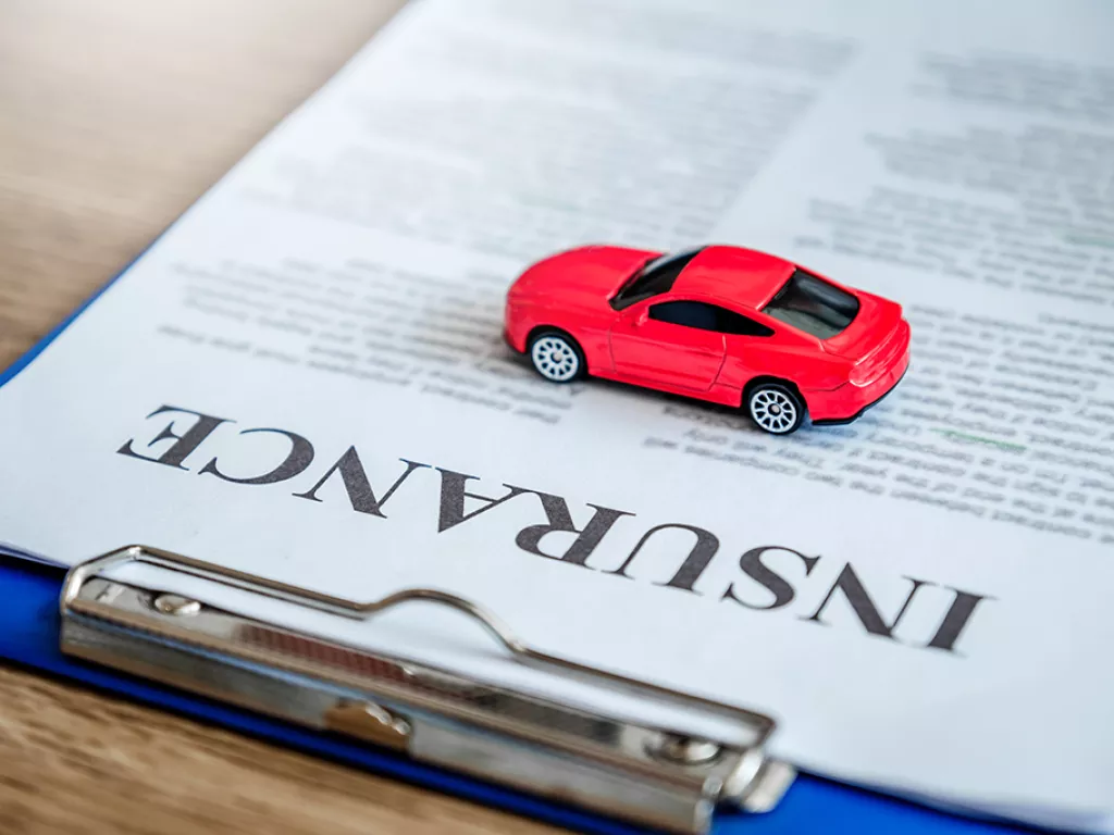 toy car on a full coverage auto insurance policy document