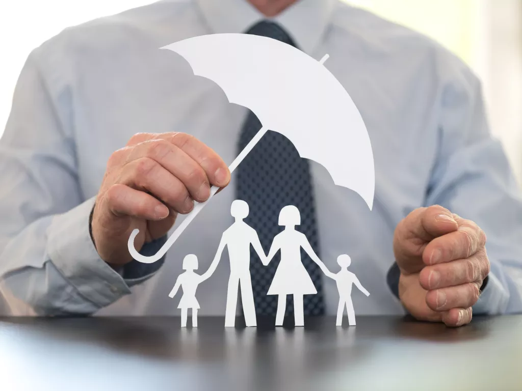 man with paper umbrella protecting family