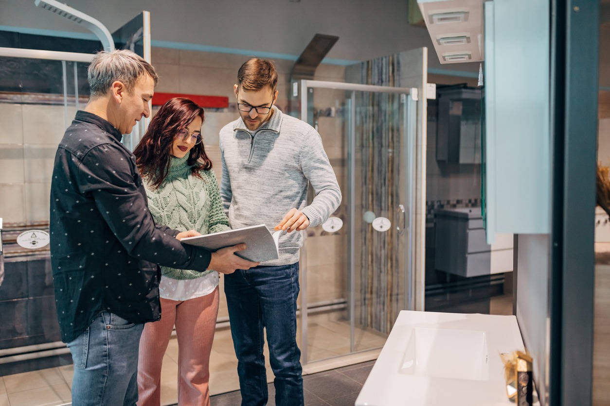 A bathroom remodeler on the phone with a client, discussing project details, friendly and welcoming background