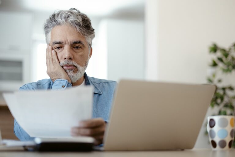 Man at computer reading options between debt relief and bankruptcy