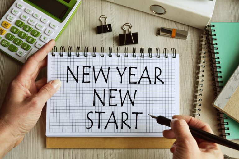 Setting new years goals with calculator and written "new year new start". Getting out of debt concept.