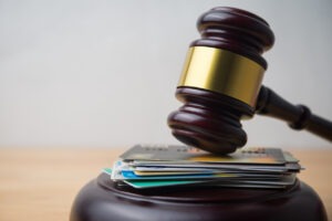 Close up judge hammer gavel on many credit card with white wall background copy space.