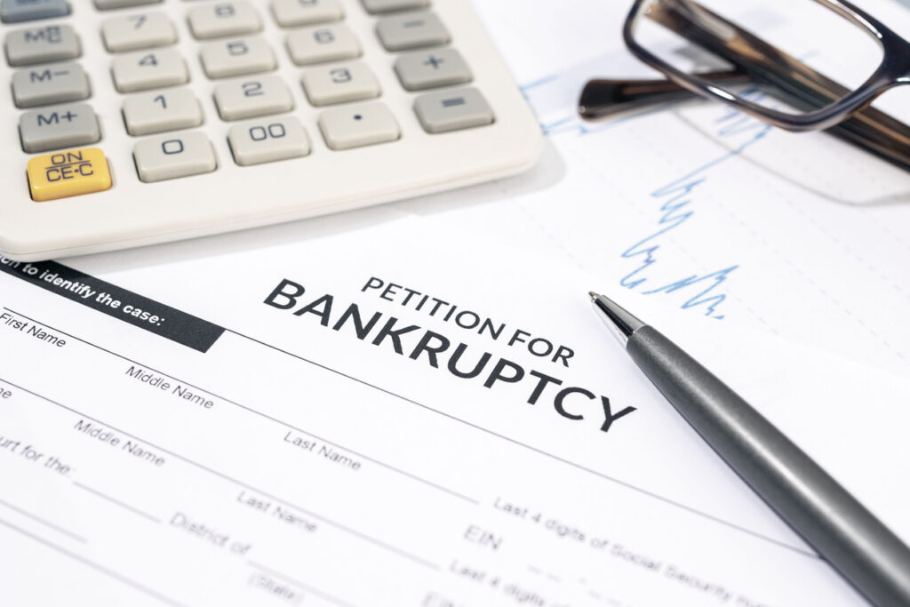 Close up of a Bankruptcy form, calculator and pen on desk. Personal injury claim form