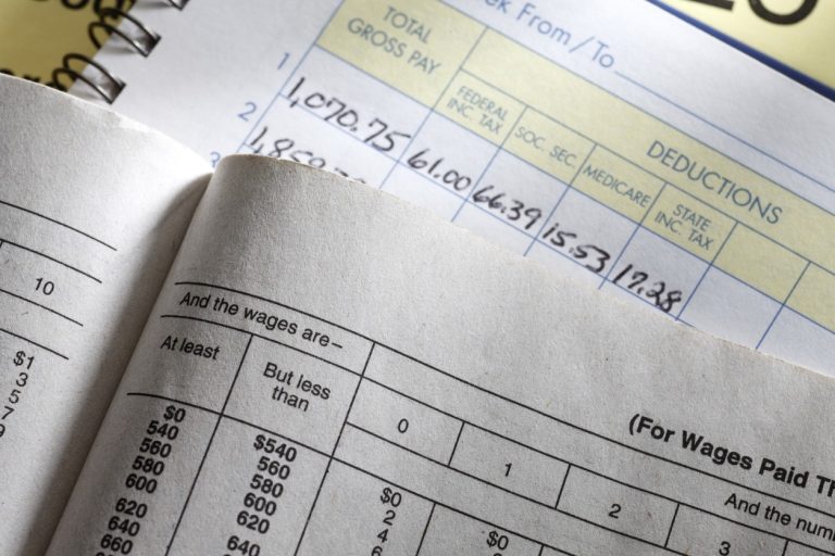 A calculator sitting on a payroll ledger