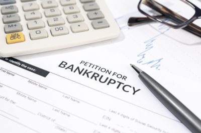 Close up of a Bankruptcy form, calculator and pen on desk. Personal injury claim form