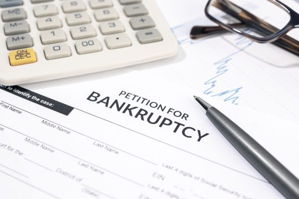 Close up of a Bankruptcy form, calculator and pen on desk. Personal injury claim form