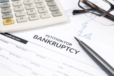 Close up of a Bankruptcy form, calculator and pen on desk. Personal injury claim form