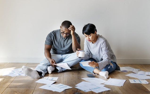 Couple managing a pile of debt papers