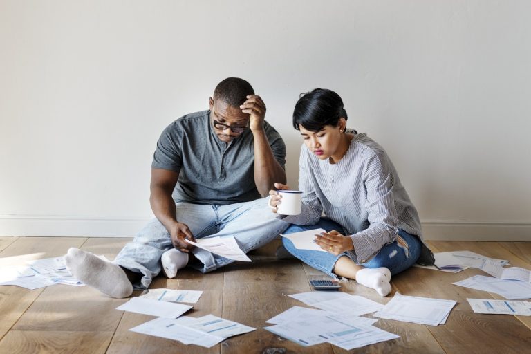 Couple managing a pile of debt papers