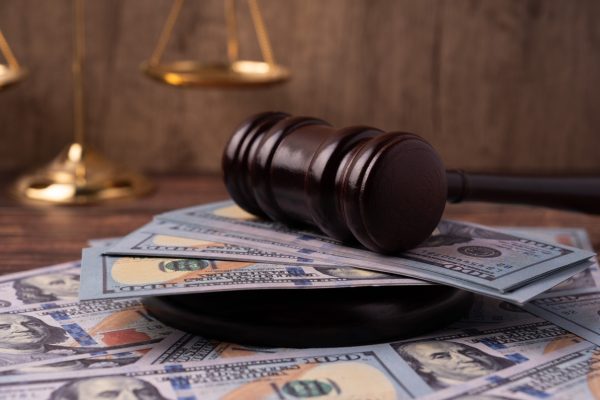 Gavel on top of American 100 dollars money and scale of justice