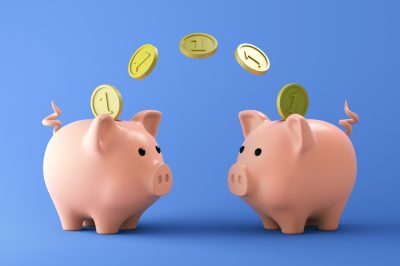 Two Pink piggy bank with coins on blue background