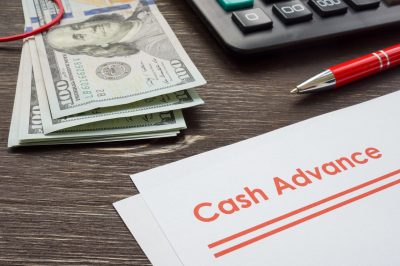 Papers for cash advance with calculator and money.
