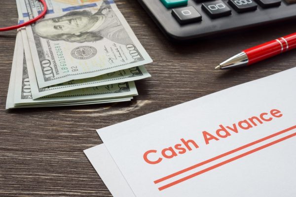 Papers for cash advance with calculator and money.