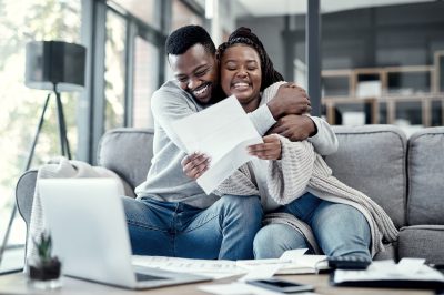 Couple on couch celebrating after paying off $20,000 in debt