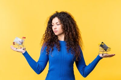 Woman standing in front of yellow background with 2 card options