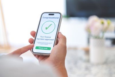 Man holding phone with loan approval on screen