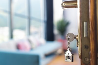 Apartment key in door with home keychain
