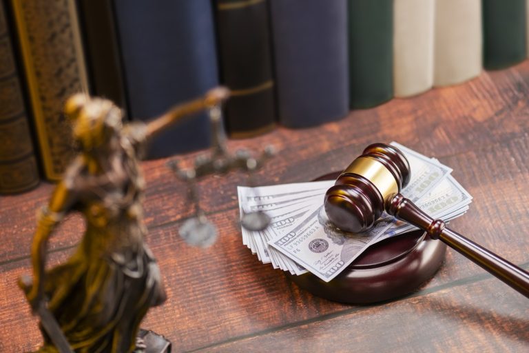 Gavel on law desk with hundred dollar bills