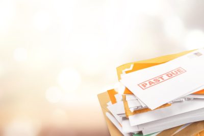 Pile of envelopes with overdue utility bills isolated on white