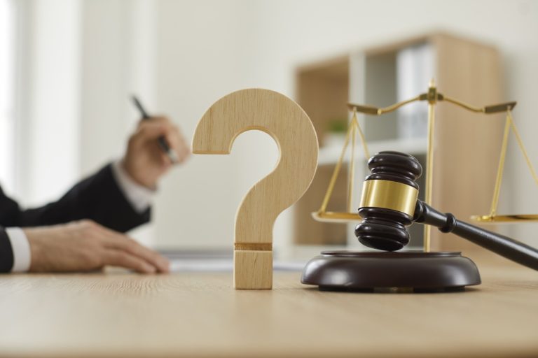 Close up of a question mark and gavel on the table in the courtroom or lawyer's office