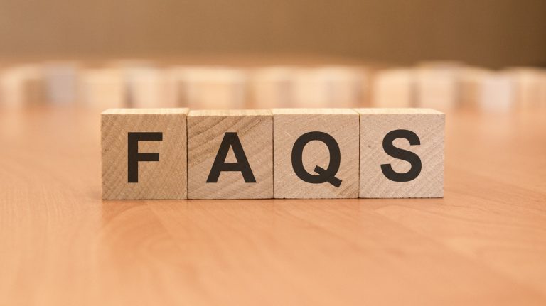 wooden blocks with word FAQS on yellow background. frequently asked question concept
