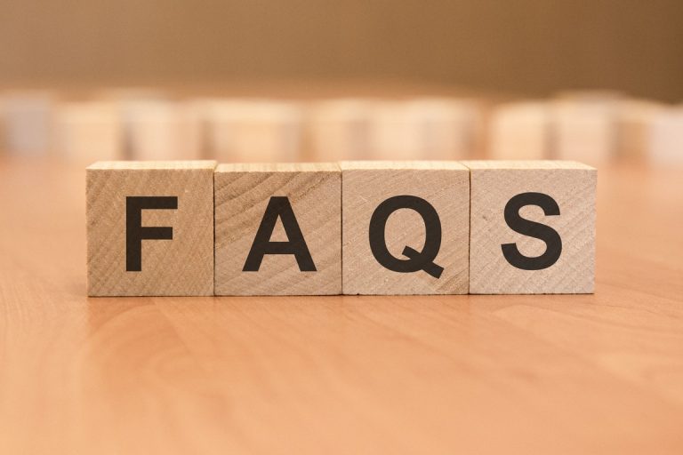 wooden blocks with word FAQS on yellow background. frequently asked question concept
