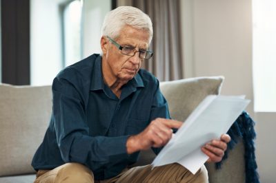 Man looking at insurance policy, deciding what option is best