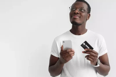Man holding a credit card and cell phone