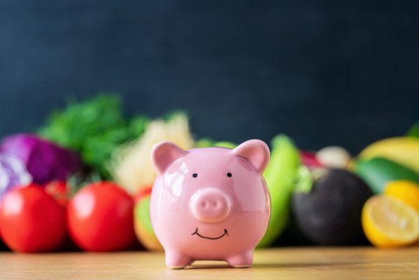 Piggy bank and healthy diet food on table