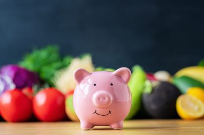 Piggy bank and healthy diet food on table