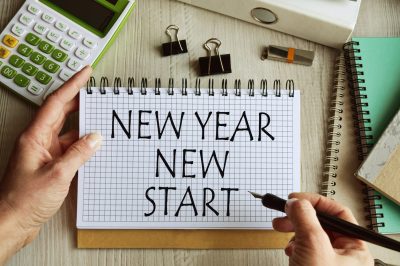 Setting new years goals with calculator and written "new year new start". Getting out of debt concept.