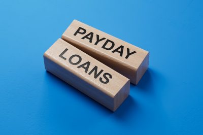 Payday loans written on wooden blocks with blue background