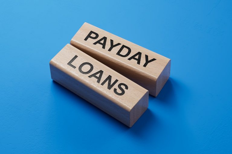Payday loans written on wooden blocks with blue background