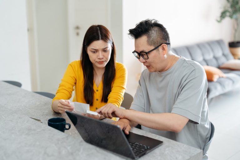 Couple at computer looking at options of paying medical debt