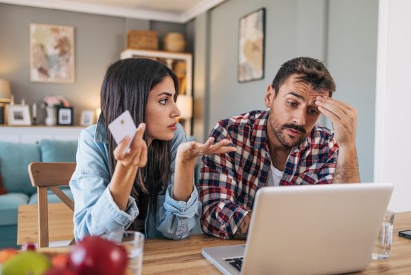 Couple at table with laptop stressed about finances and bad credit