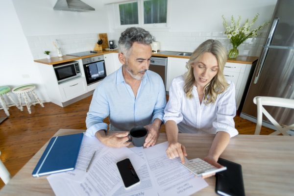 Couple at kitchen table considering loan to pay off debt