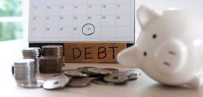 Due for repayment There are coins, calculators and calendar reminders placed on the table.