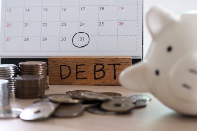 Due for repayment There are coins, calculators and calendar reminders placed on the table.