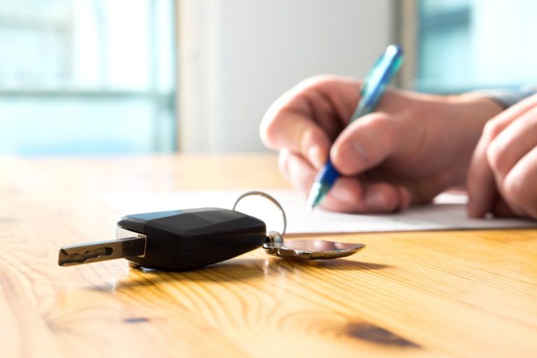 Woman signing financing documents for new car