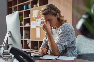 Woman at desk looking stressed