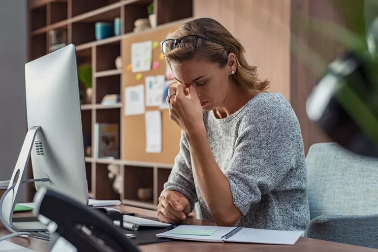 Woman at desk looking stressed