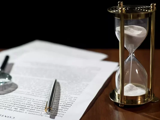 Image of paper and hourglass in legal setting