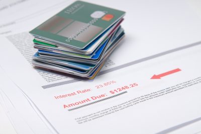 a stack of made up credit cards with a bill showing amount due