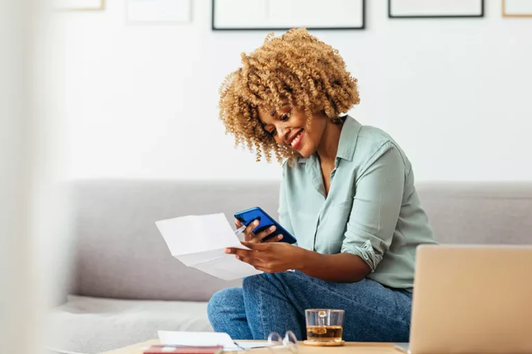Woman happy with phone and paper